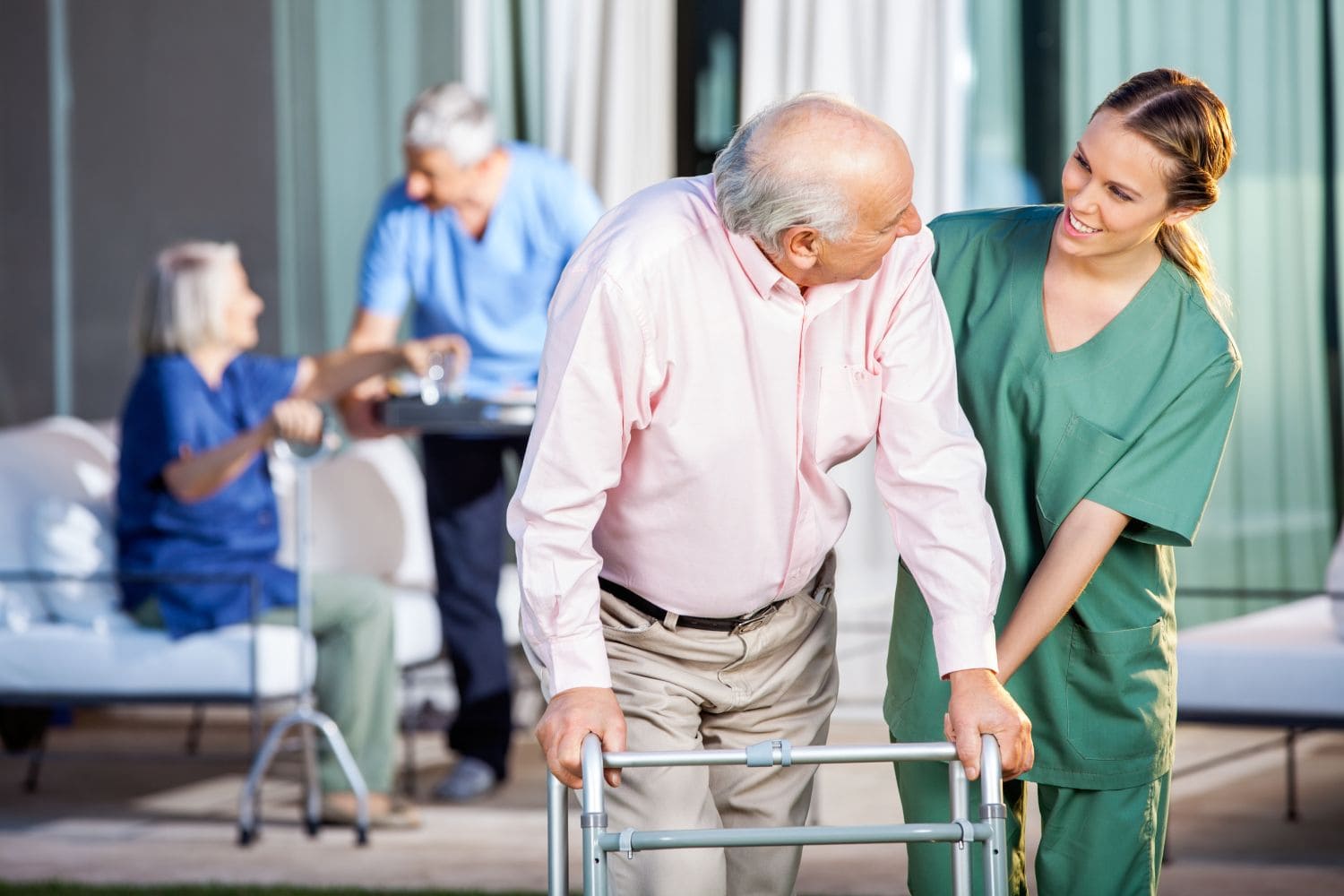 Pflegekraft unterstützt einen Senior beim Gehen